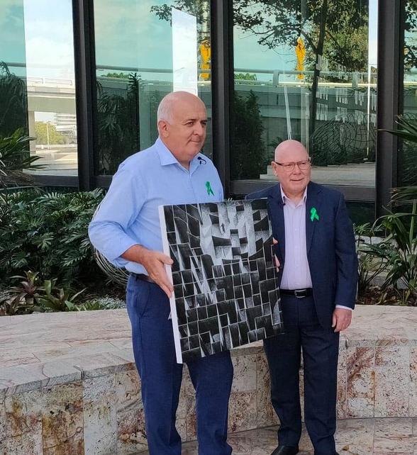 Two men holding an art print