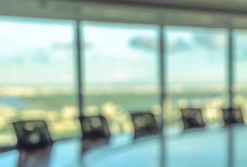 Image of boardroom table with chairs lined up ready for a meeting